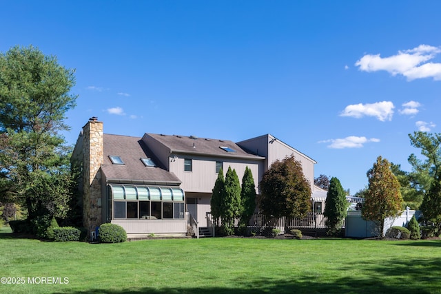 back of property featuring a lawn and a sunroom