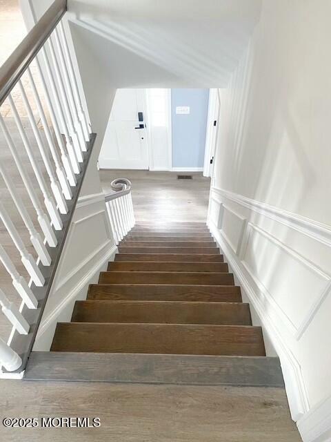 stairway with hardwood / wood-style flooring