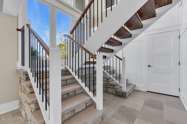 stairs with baseboards and stone finish floor