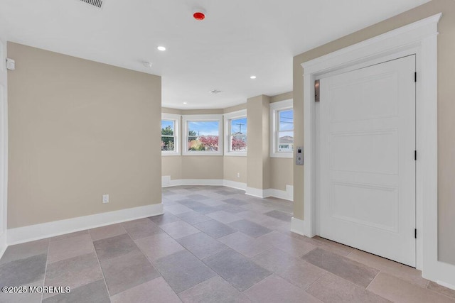 spare room featuring baseboards and recessed lighting