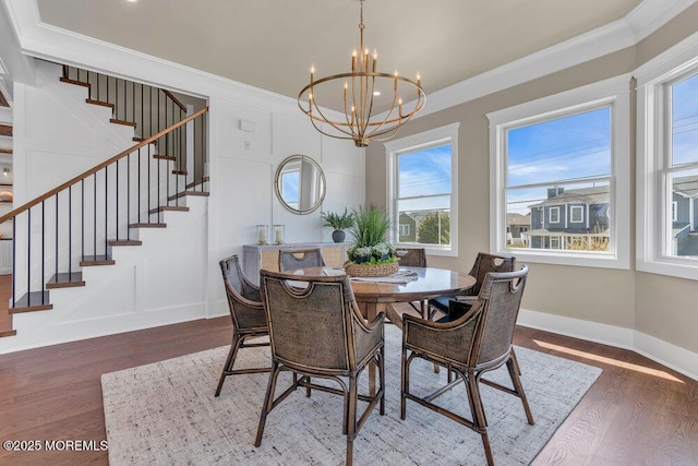 dining room with plenty of natural light, stairs, wood finished floors, and a chandelier