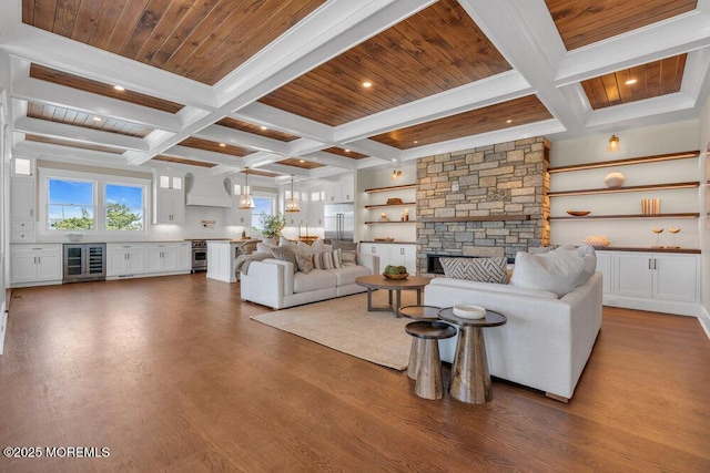 living area featuring beamed ceiling, coffered ceiling, and beverage cooler