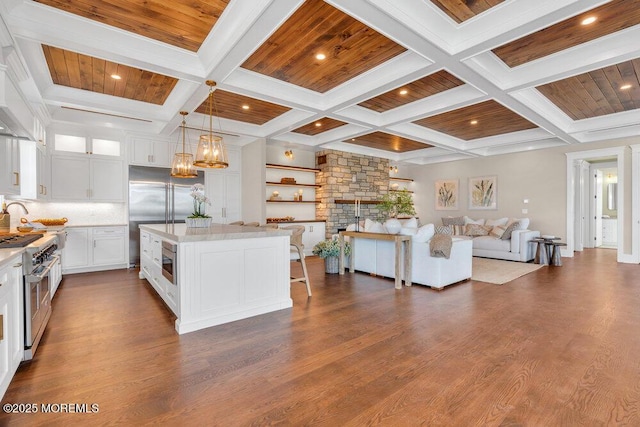 kitchen featuring white cabinets, dark wood-style floors, open floor plan, built in appliances, and coffered ceiling