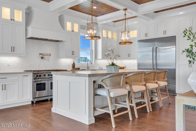 kitchen featuring white cabinets, beam ceiling, premium range hood, a center island, and premium appliances