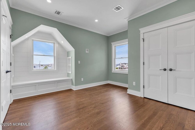 additional living space with baseboards, wood finished floors, and visible vents