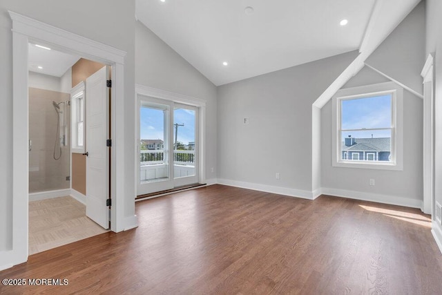 interior space with baseboards, vaulted ceiling, and wood finished floors