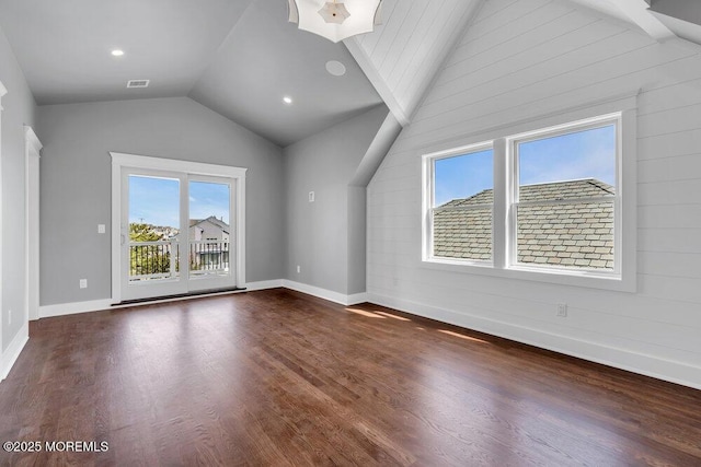 additional living space featuring a healthy amount of sunlight, visible vents, dark wood-type flooring, and lofted ceiling