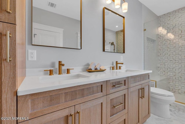 full bathroom featuring toilet, visible vents, a shower stall, and a sink