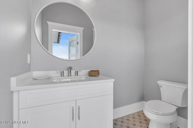 bathroom with vanity, baseboards, and toilet
