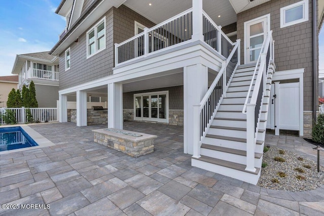 view of patio featuring a fenced in pool, fence, and stairs