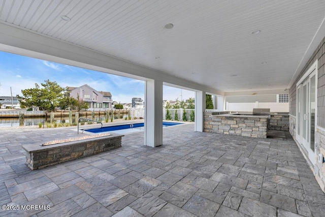 view of patio with an outdoor kitchen, a fenced in pool, a fenced backyard, and grilling area