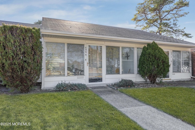 ranch-style home featuring a front yard and a sunroom