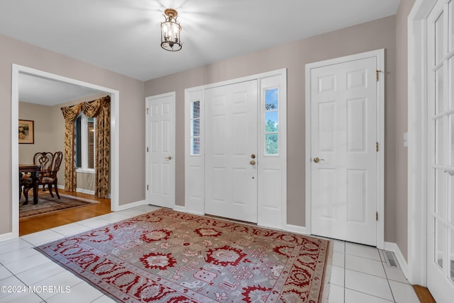 entryway featuring light tile patterned flooring and a notable chandelier