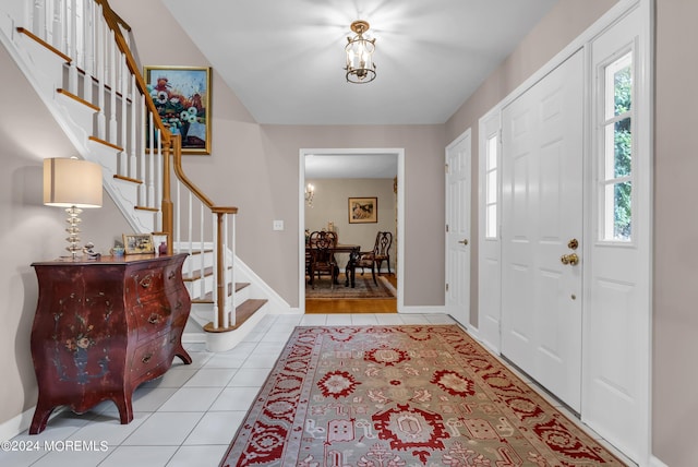 tiled entryway with an inviting chandelier