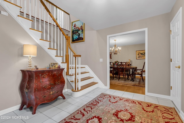 tiled foyer featuring an inviting chandelier