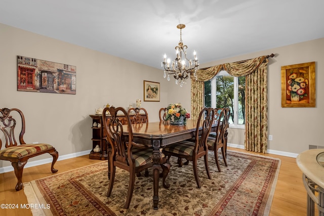 dining space with an inviting chandelier and light hardwood / wood-style floors