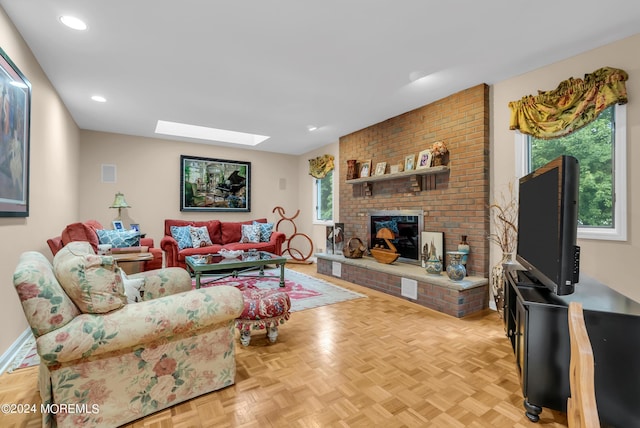 living room featuring light parquet flooring, a fireplace, and a skylight