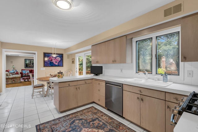 kitchen with pendant lighting, sink, stainless steel appliances, kitchen peninsula, and light brown cabinets