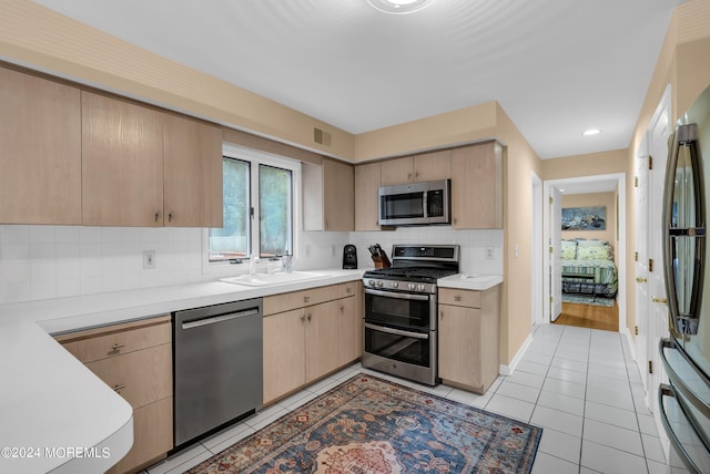 kitchen featuring tasteful backsplash, stainless steel appliances, sink, and light brown cabinets