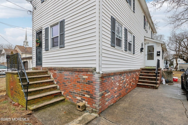 view of home's exterior with entry steps and brick siding