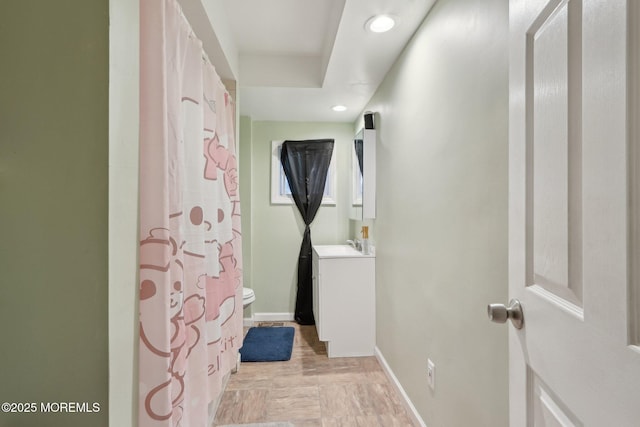 bathroom with toilet, recessed lighting, baseboards, and vanity