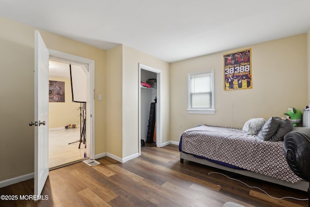 bedroom featuring a closet, baseboards, and dark wood-style flooring