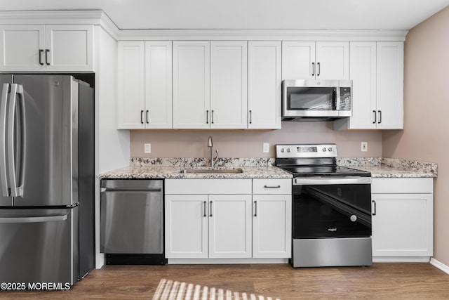 kitchen featuring stainless steel appliances, white cabinetry, and sink