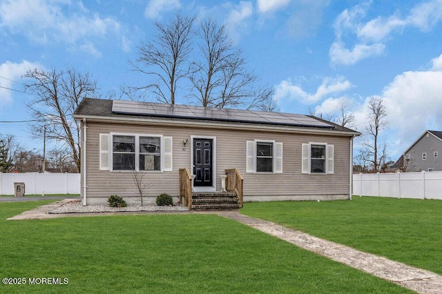 view of front of house featuring a front lawn and solar panels