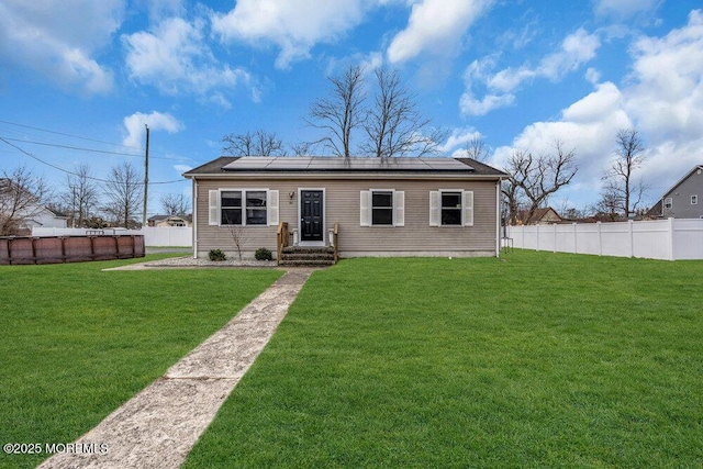 view of front of home featuring a front lawn and solar panels