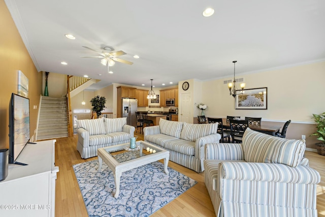 living room featuring crown molding, light hardwood / wood-style flooring, and ceiling fan with notable chandelier