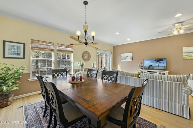 dining room featuring crown molding, ceiling fan with notable chandelier, and light hardwood / wood-style flooring