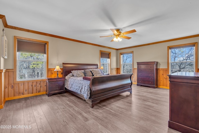 bedroom with crown molding, ceiling fan, and light hardwood / wood-style flooring