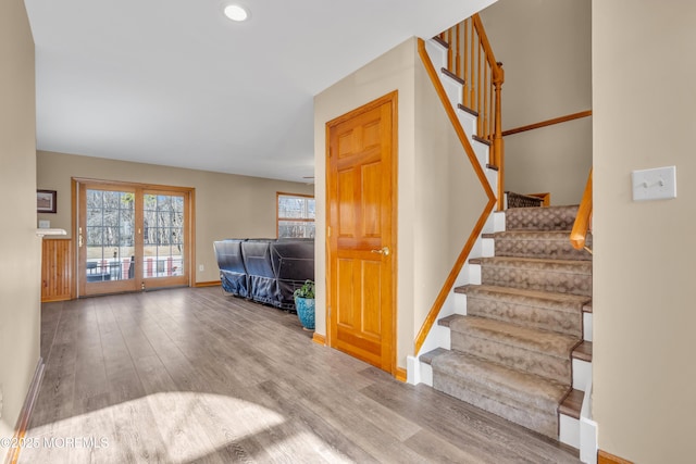 staircase featuring hardwood / wood-style flooring, plenty of natural light, and french doors