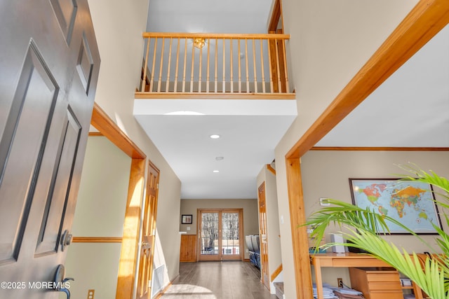 hallway with a high ceiling, hardwood / wood-style floors, and french doors