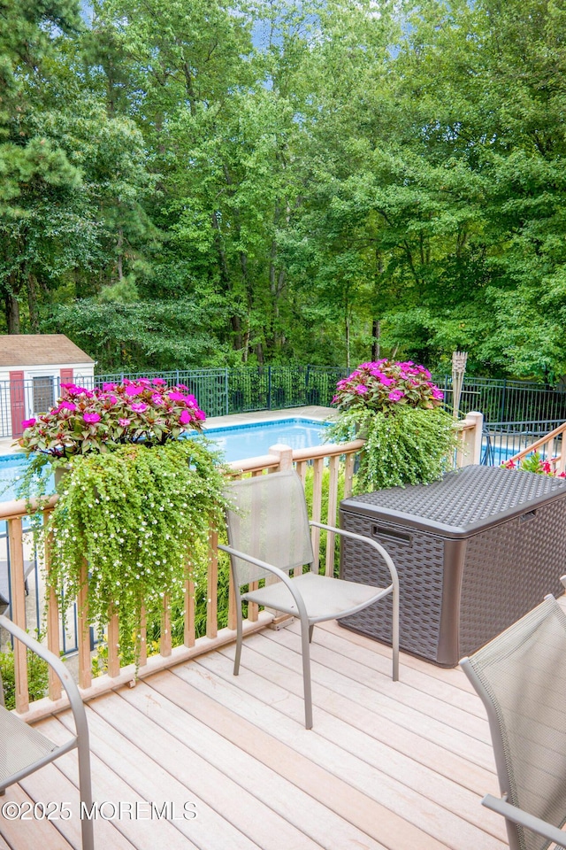 wooden deck with a fenced in pool