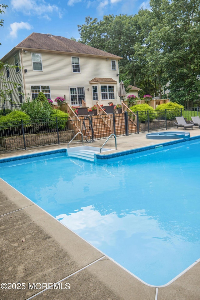 view of swimming pool featuring a jacuzzi and a patio area