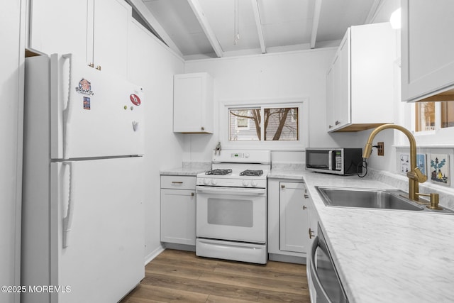 kitchen with white appliances, sink, and white cabinets