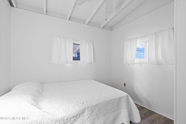 bedroom with hardwood / wood-style flooring and vaulted ceiling with beams