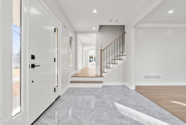 foyer entrance featuring crown molding