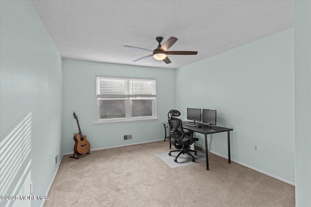 carpeted home office featuring visible vents, ceiling fan, a textured ceiling, and baseboards