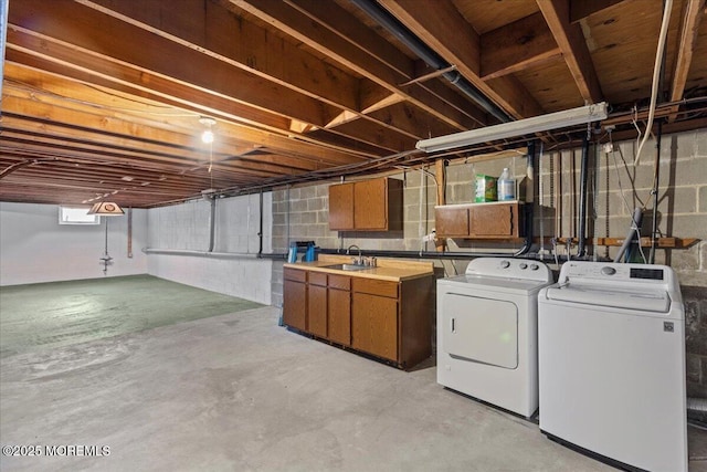 basement with a sink and washing machine and clothes dryer