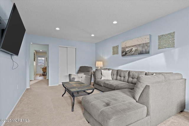 living area with light carpet, baseboards, a textured ceiling, and recessed lighting