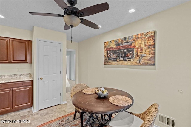 dining room with a ceiling fan, visible vents, a textured ceiling, and recessed lighting