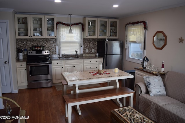 kitchen featuring sink, crown molding, hanging light fixtures, appliances with stainless steel finishes, and backsplash