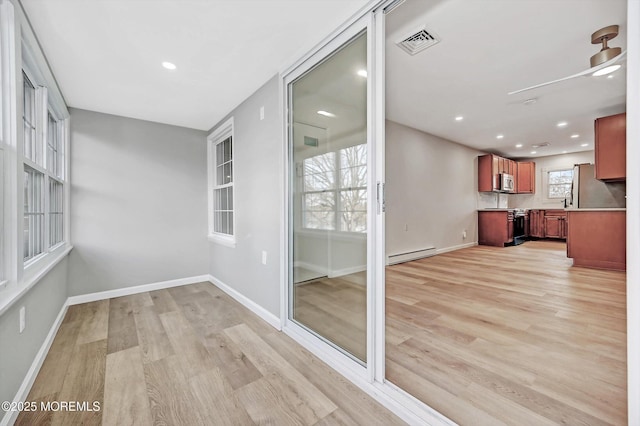 interior space featuring visible vents and a baseboard heating unit