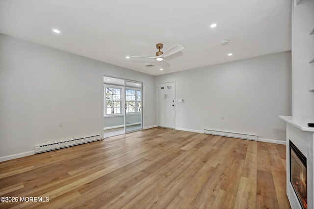 unfurnished living room with a glass covered fireplace, a baseboard radiator, light wood-style flooring, a baseboard heating unit, and recessed lighting