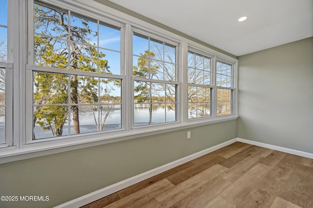 unfurnished sunroom with a water view