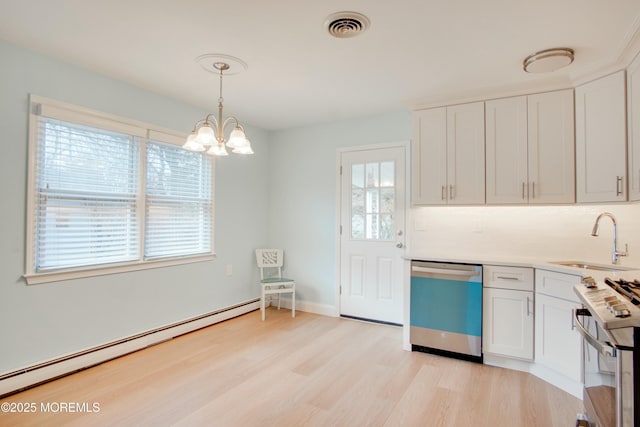 kitchen featuring a baseboard radiator, visible vents, a sink, appliances with stainless steel finishes, and white cabinets