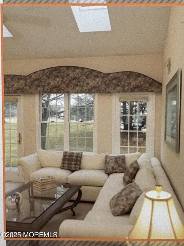 living area featuring lofted ceiling with skylight