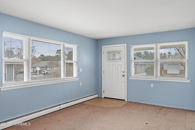 carpeted foyer entrance featuring a baseboard heating unit and a wealth of natural light